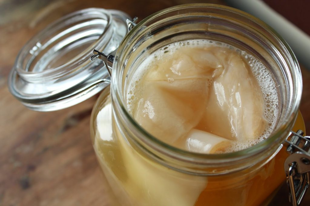 SCOBY (Symbiotic Culture Of Bacteria and Yeast) in a clear glass jar, showcasing its layered structure and texture.